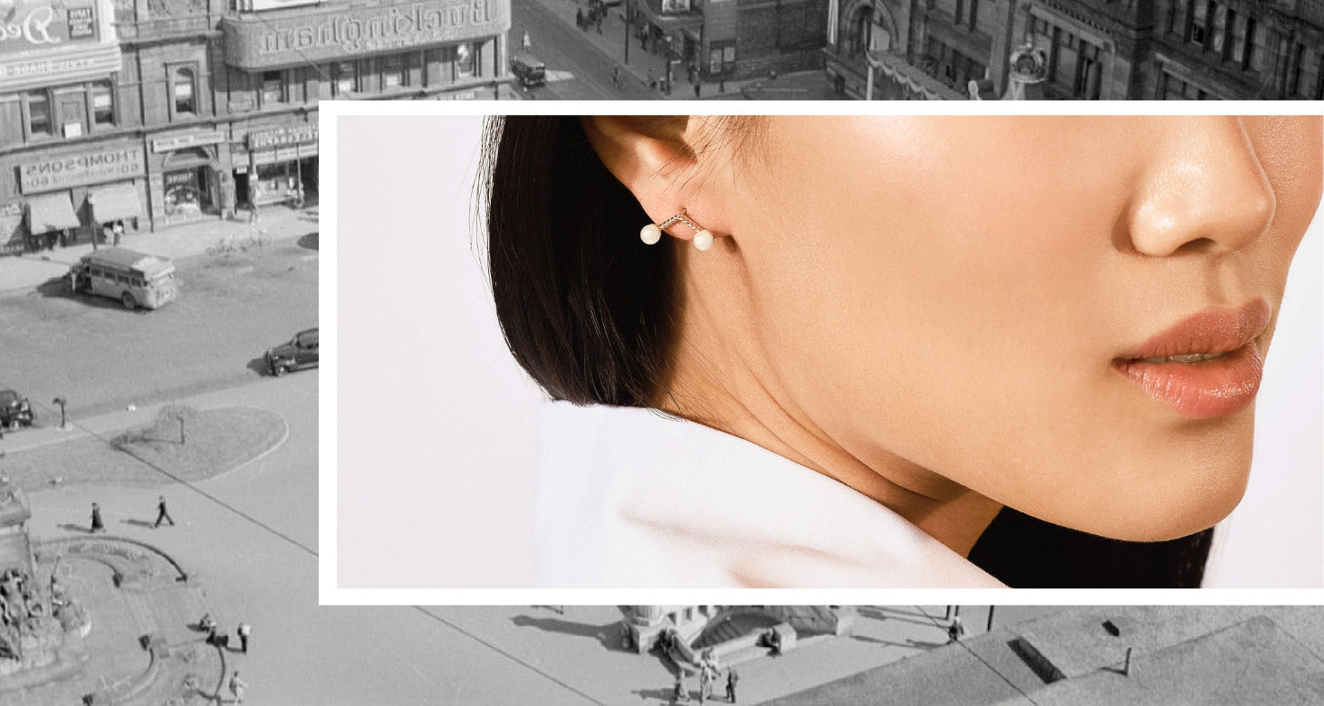 A woman models a Canadian-made 18K Yellow Gold ear climber with two Akoya Pearls from Jewellers District Montreal.