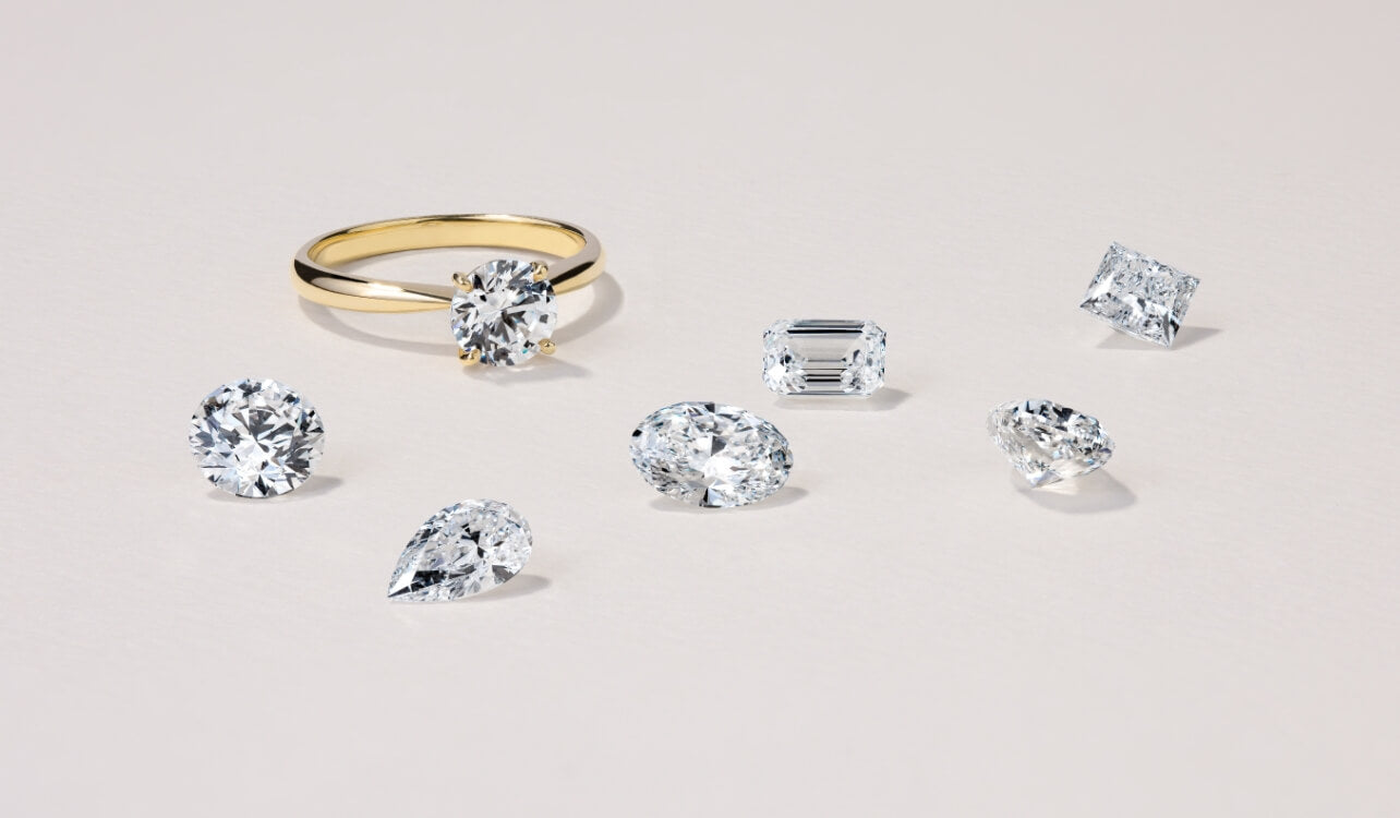 An 18K yellow gold oval diamond engagement ring with various loose diamond shapes. Canadian-made by Jewellers District.