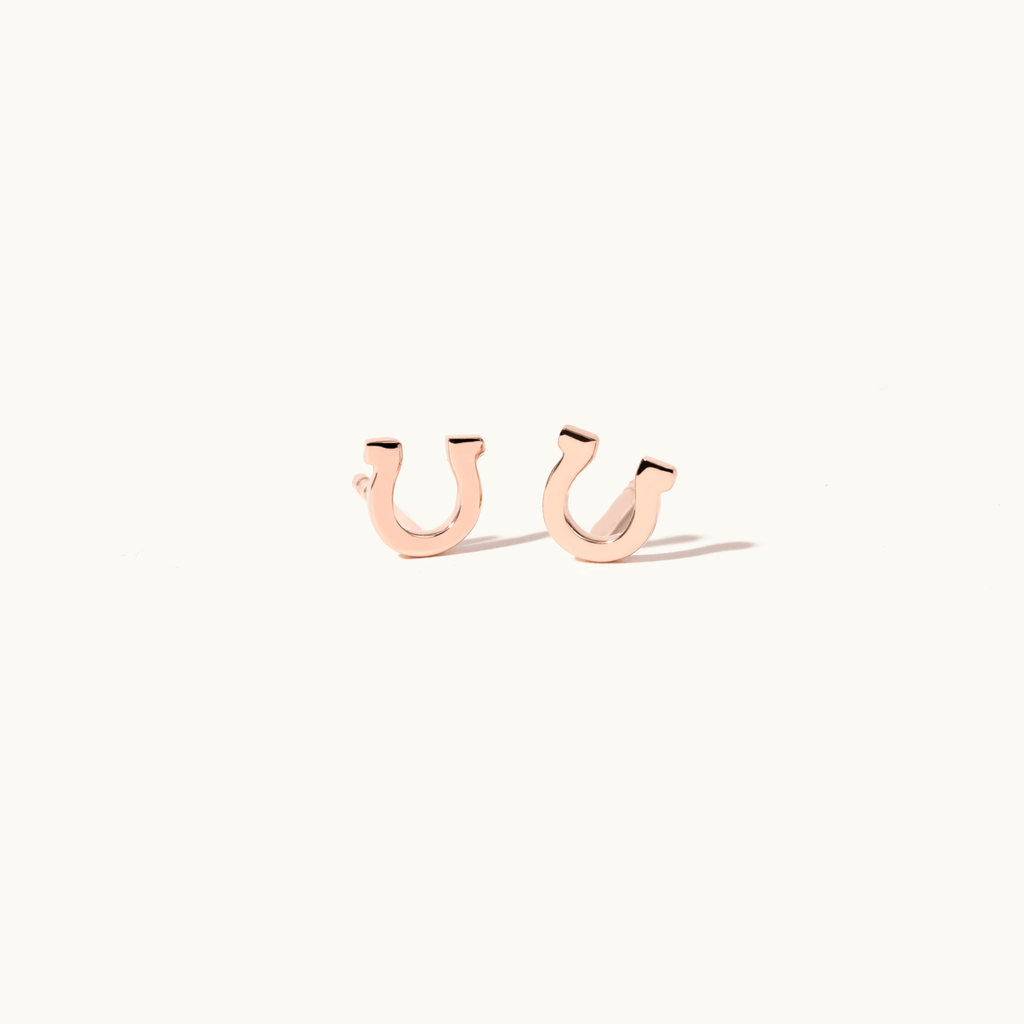 Angled view of Jewellers District's Gold Horseshoe Stud Earrings in 14k Rose Gold