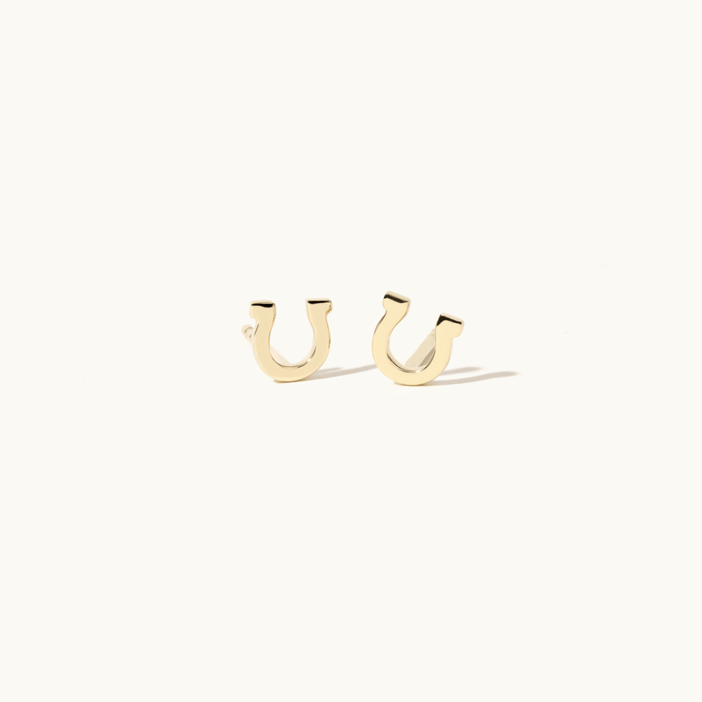 Angled view of Jewellers District's Gold Horseshoe Stud Earrings in 14k Yellow Gold