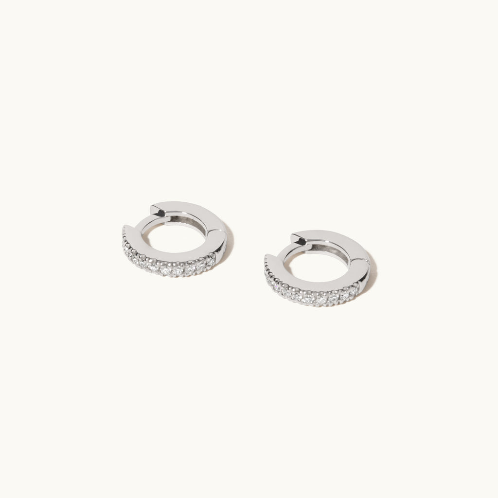 Angled view of Jewellers District's Petite Diamond Hoop Earrings in 14k White Gold