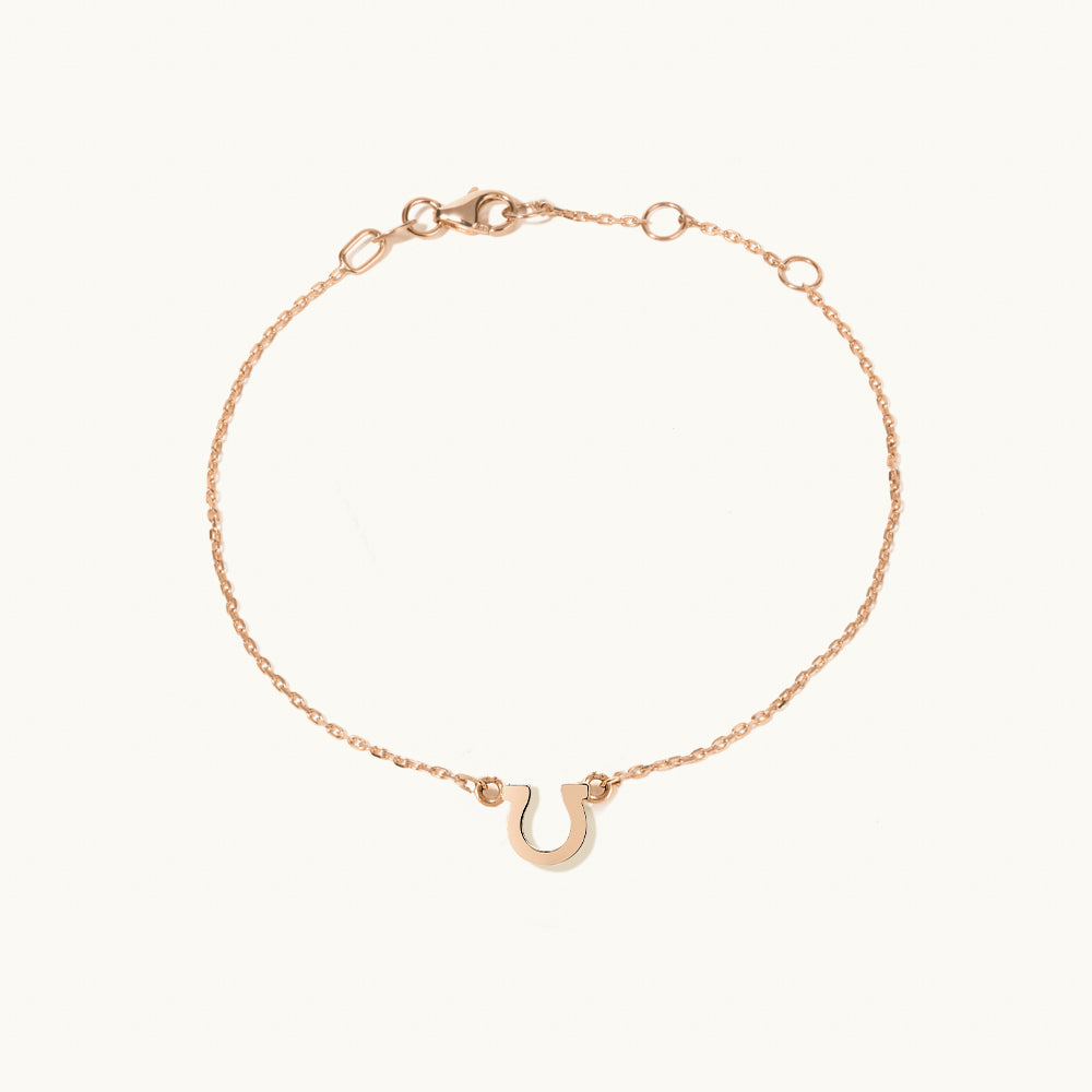 Face view of Jewellers District's Petite Gold Horseshoe Charm Bracelet in 14k Rose Gold