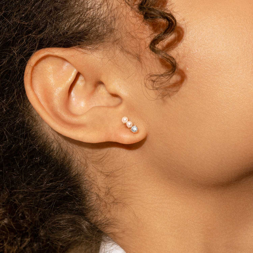 Model wearing Jewellers District's Three-Stone Pearl and Diamond Bar Earrings in 14k Rose Gold #2