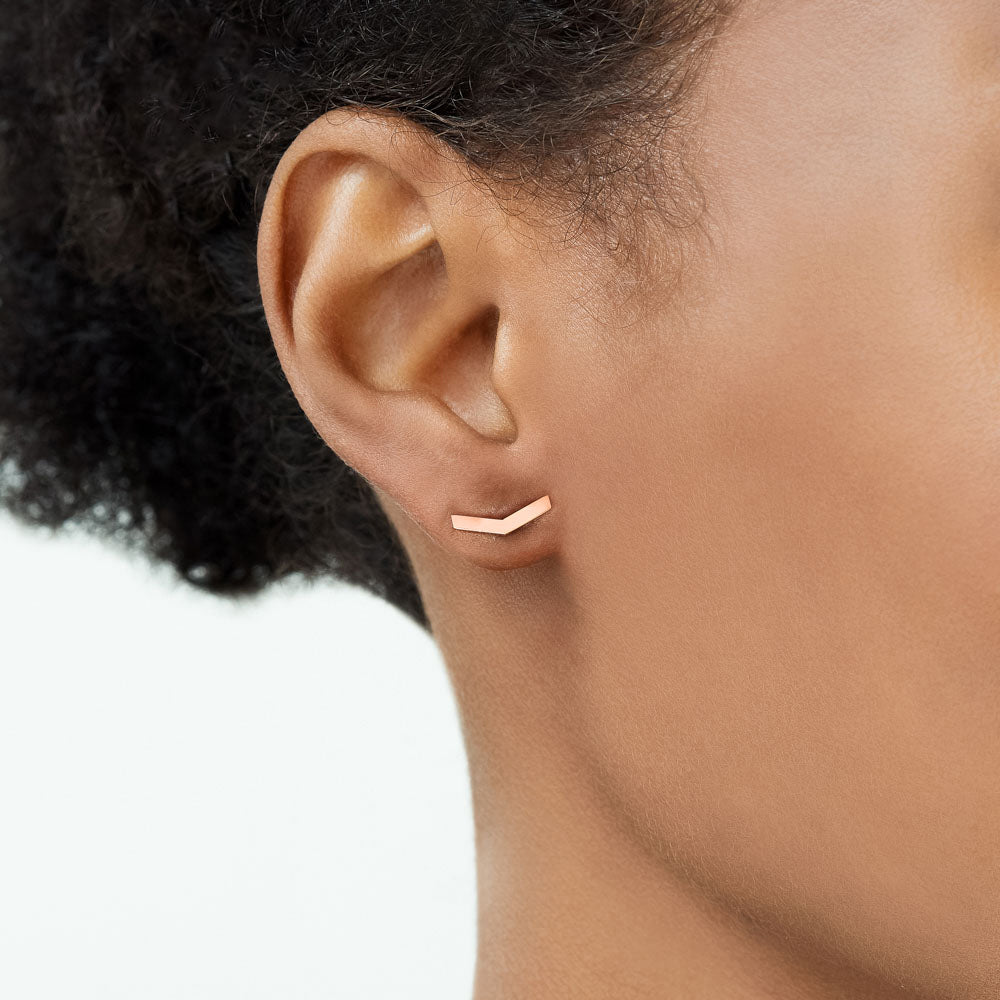 Model wearing Jewellers District's V-Shaped Gold Stud Earrings in 10k Rose Gold #3