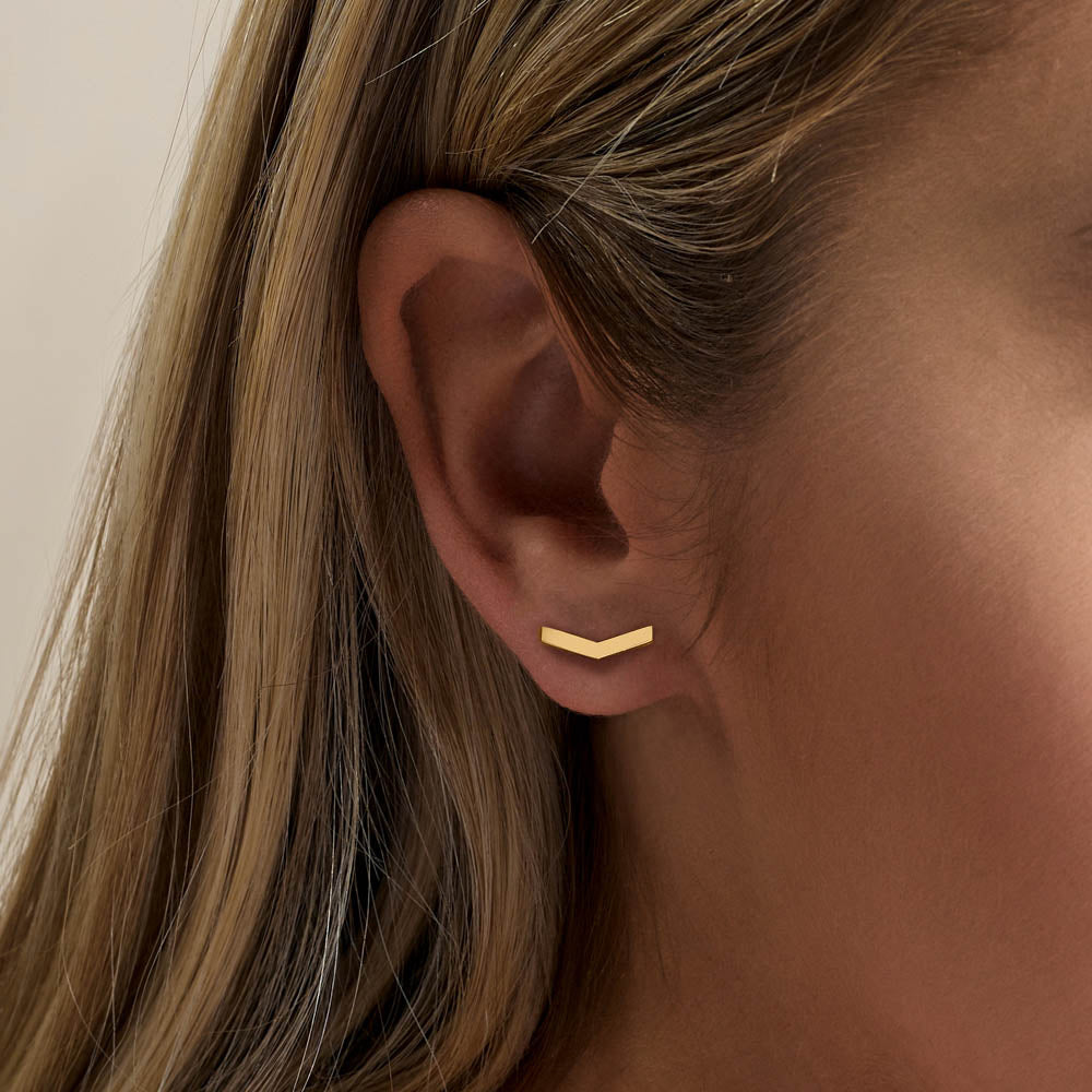 Model wearing Jewellers District's V-Shaped Gold Stud Earrings in 10k Yellow Gold #4