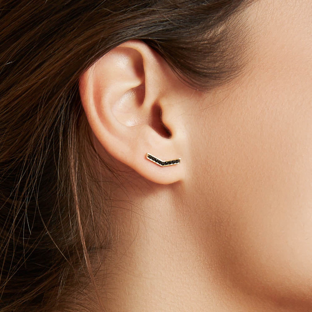 Model wearing Jewellers District's V-Shaped Stud Earrings with Accent Black Spinels in 14k Yellow Gold