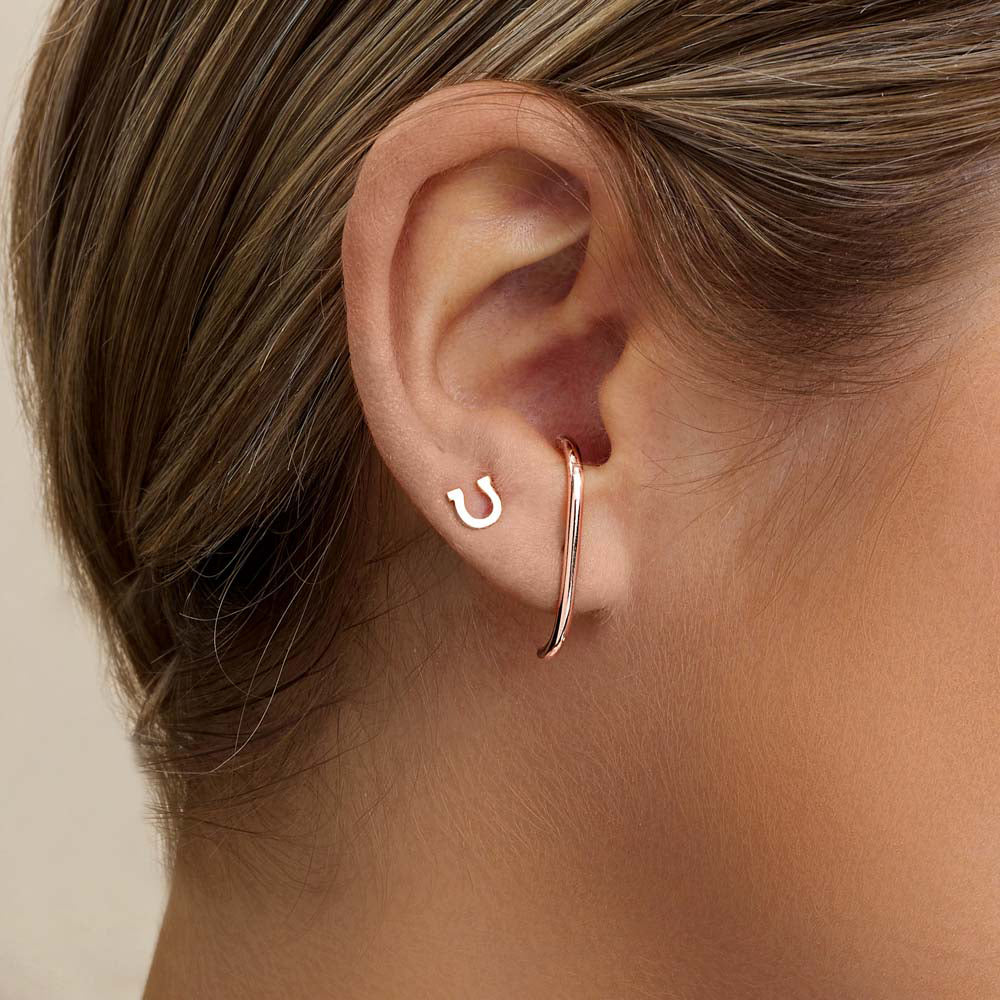 Model wearing Jewellers District's Gold Horseshoe Stud Earrings in 10k Rose Gold