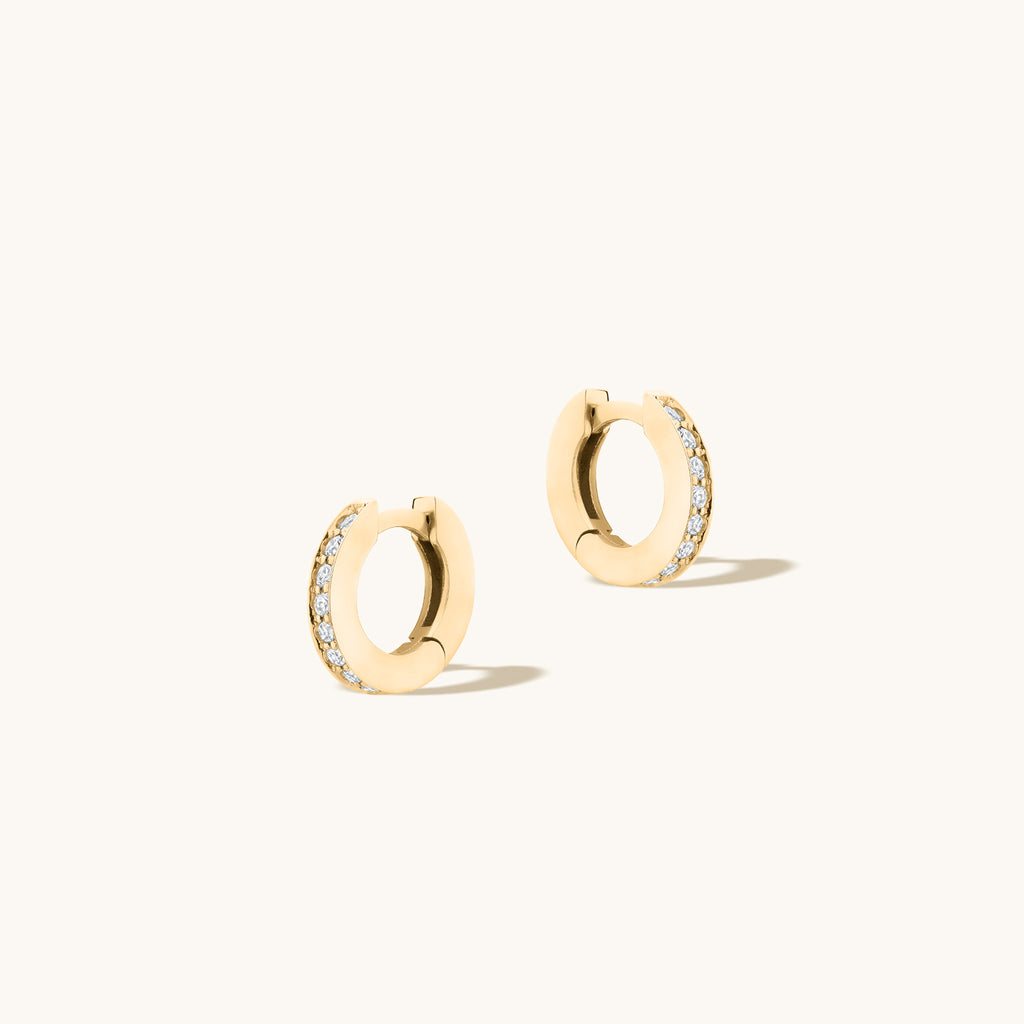 Angled view of Jewellers District's Diamond Hoop Earrings with Bright-Cut Setting in 10k Yellow Gold