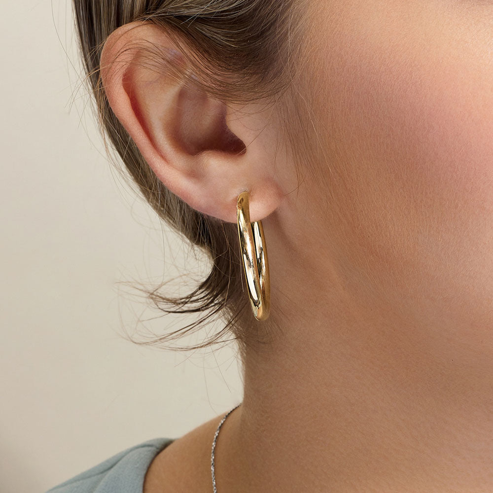 Model wearing Jewellers District's Gold Hoop Earrings in 14k Yellow Gold