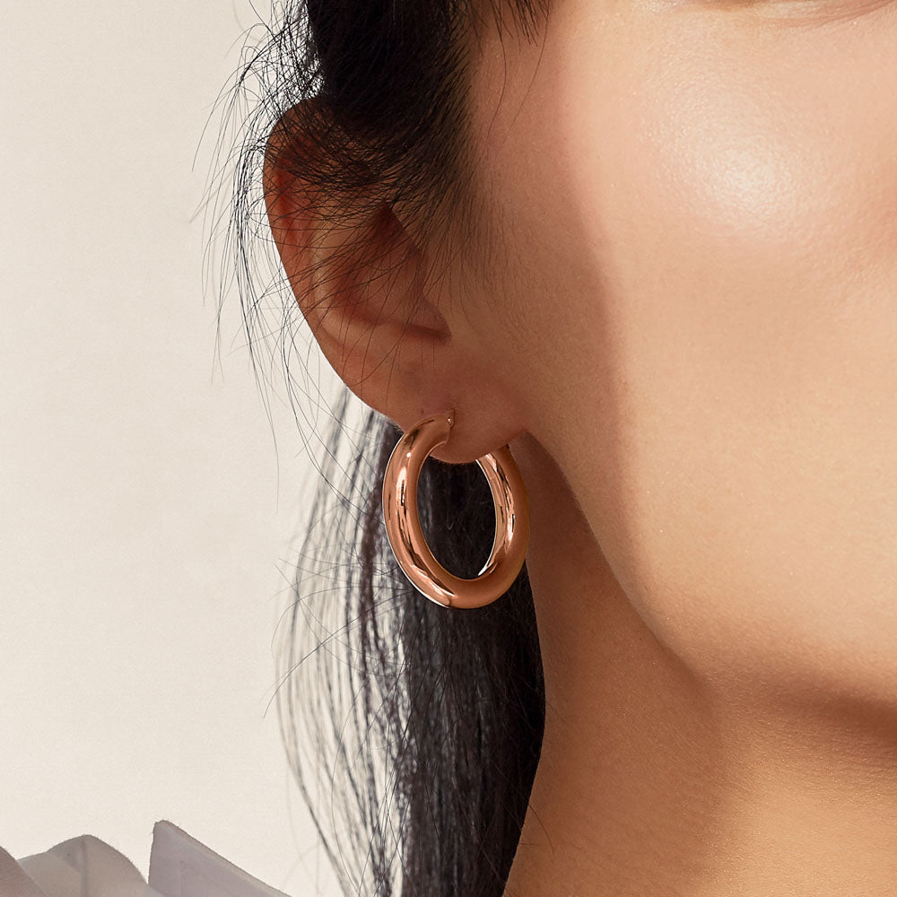 Model wearing Jewellers District's Bold Gold Hoop Earrings in 10k Rose Gold