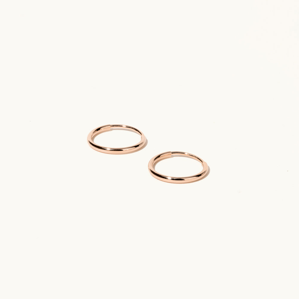 Profile view of Jewellers District's Petite Gold Hoop Earrings in 14k Rose Gold