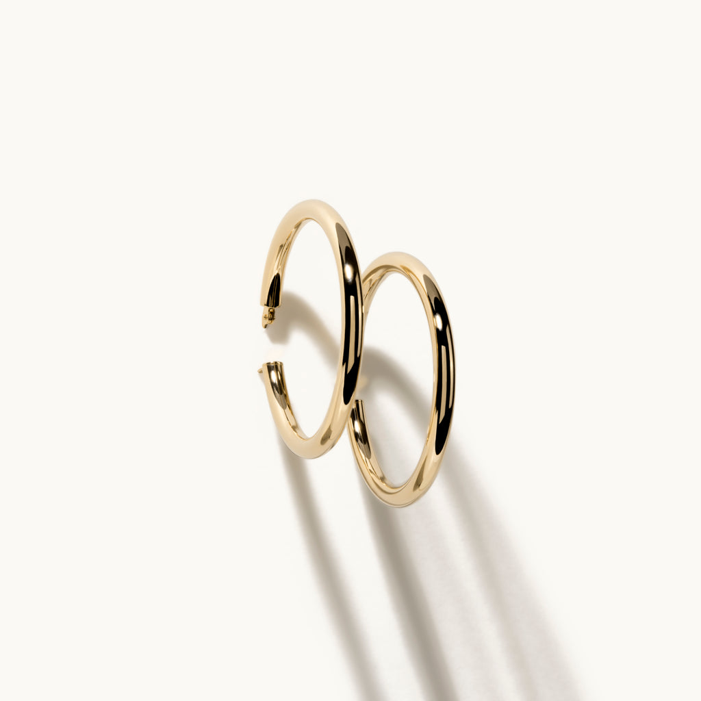 Angled view of Jewellers District's Thin Gold Hoop Earrings in 14k Yellow Gold