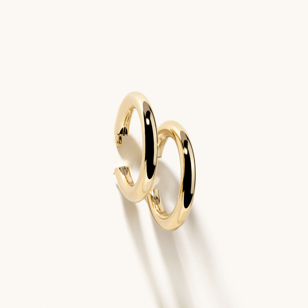 Angled view of Jewellers District's Thick Gold Hoop Earrings in 14k Yellow Gold