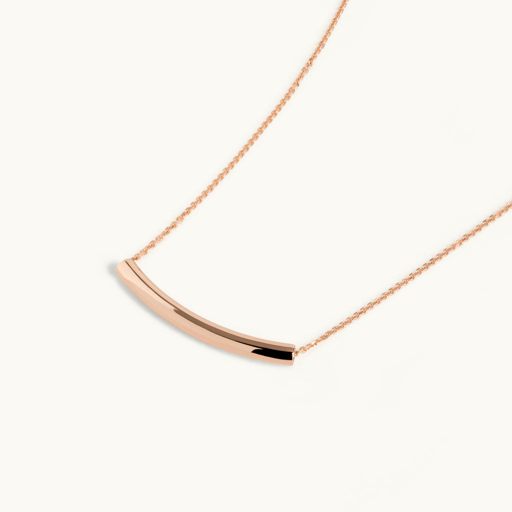 Angled view of Jewellers District's Arc of Life Curved Gold Necklace in 10k Rose Gold