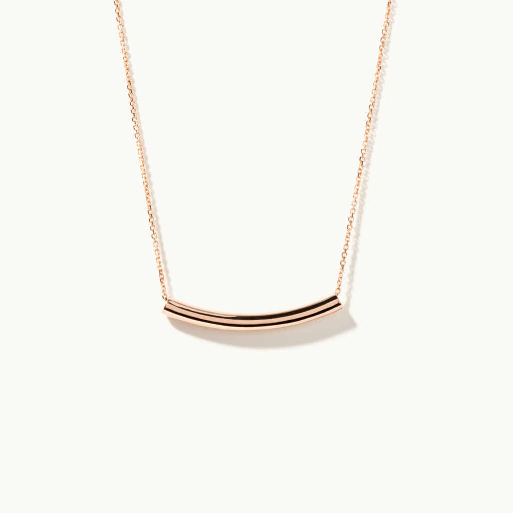 Standing view of Jewellers District's Arc of Life Curved Gold Necklace in 10k Rose Gold